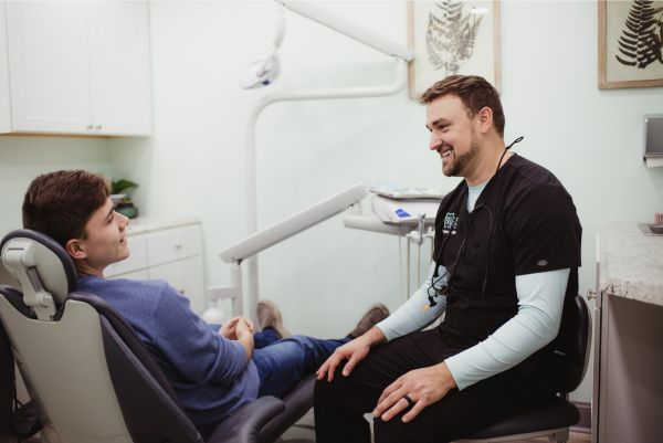 Dr. Huffman sitting with a patient smiling