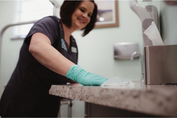 A belpre dental studio employee wiping down a counter